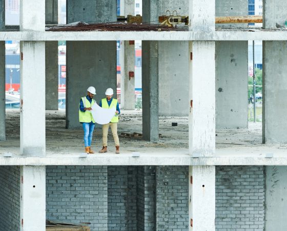 Two Builders Holding Construction Plans